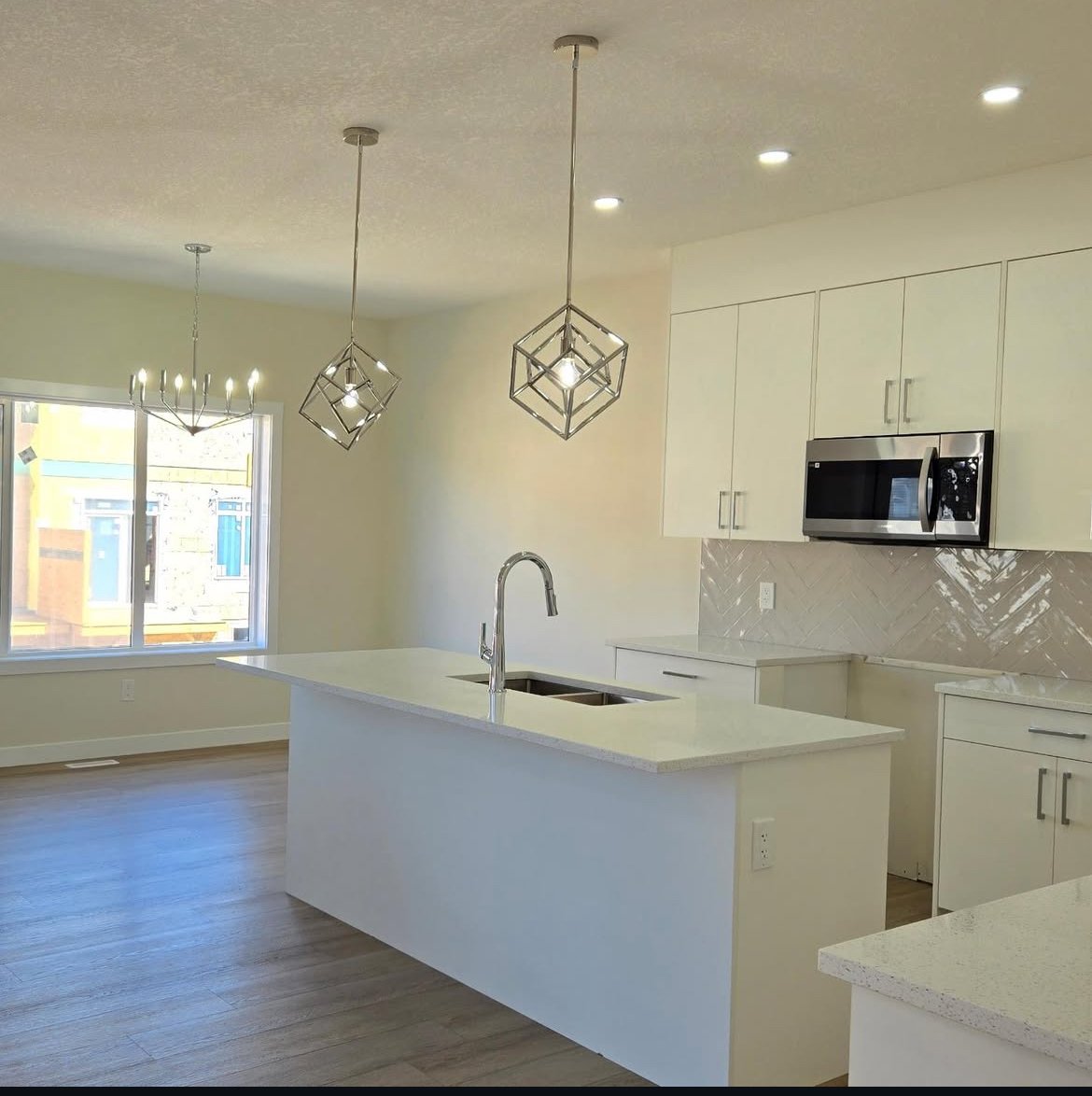 Bright renovated kitchen with custom pendant lights and pot lighting